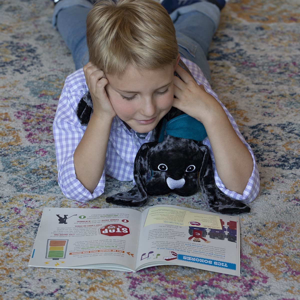 Child reading with a 2 kg manimo dog plush on their lap, illustrating the plush’s calming effect during quiet activities.