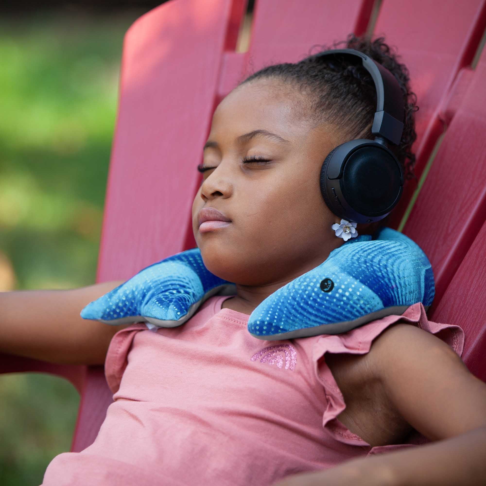 Teenager resting with a 2 kg manimo blue weighted dolphin plush, showing how it provides sensory support and relaxation.